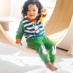 Child wearing the Miffy on the Move bamboo lounge set with bicycle sweatshirt and green joggers