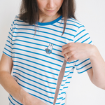 Vrouw die het nijntje gestreepte borstvoedings-T-shirt met verborgen borstvoedingsritsen draagt